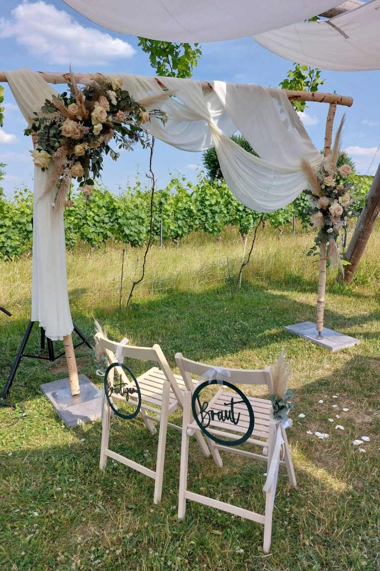 Trausetting mit Traubogen und Brautpaarstühlen Bohohochzeit Weingut Pfalz Hochzeitsplanung Katrin Hoessler fiderallala Traumhochzeiten